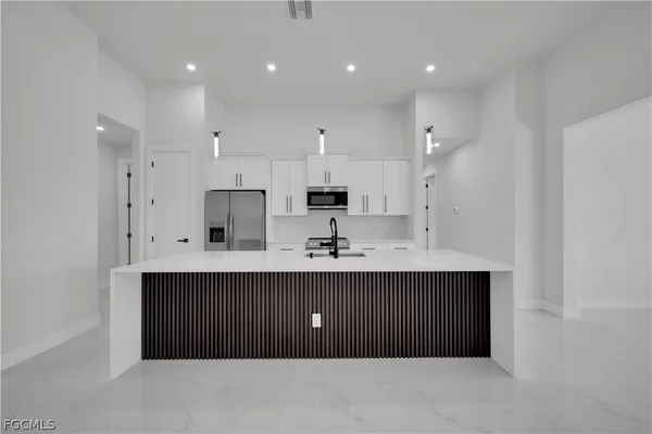 a kitchen with kitchen island sink and cabinets