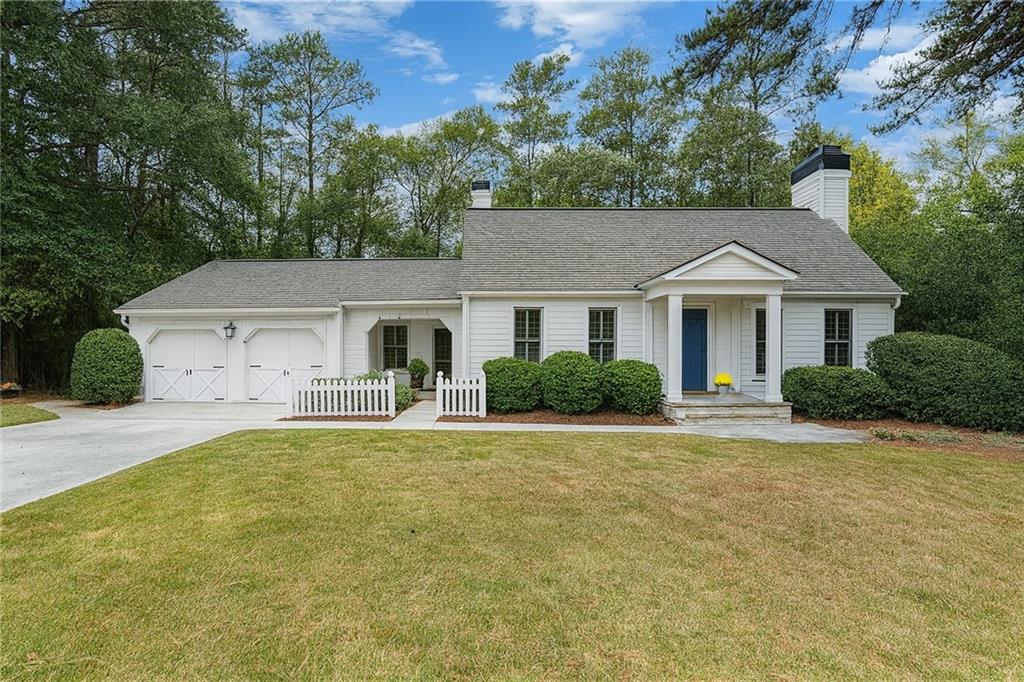 4220 Exeter Close Northwest Atlanta, GA 30327 - Photo 2 of 61 a front view of a house with a yard and garage