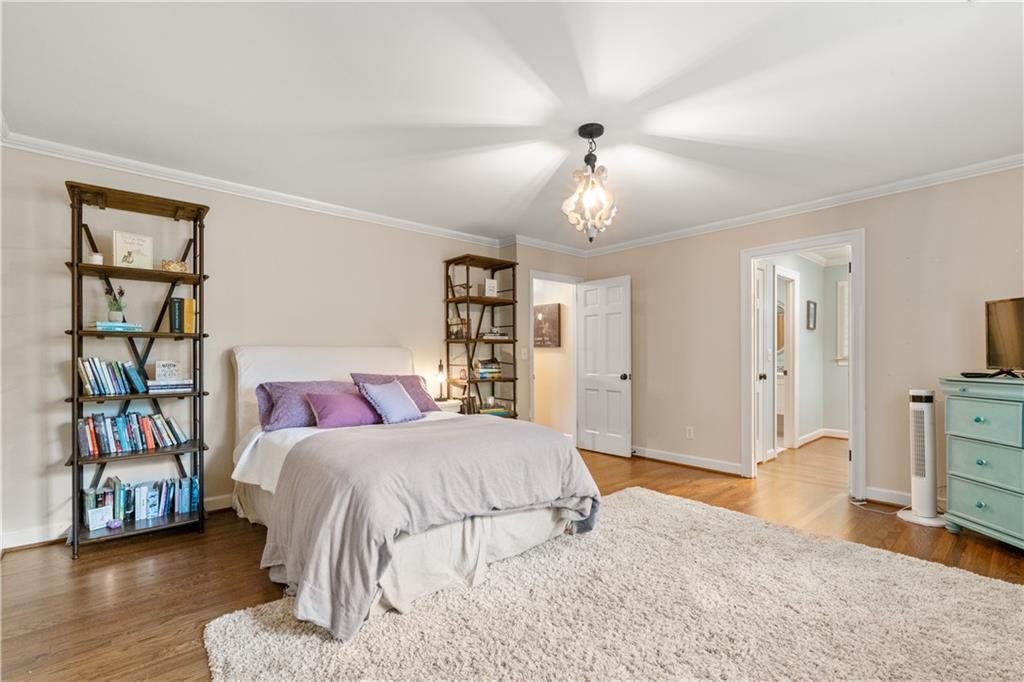 4220 Exeter Close Northwest Atlanta, GA 30327 - Photo 39 of 61 a bedroom with a large bed and a chandelier