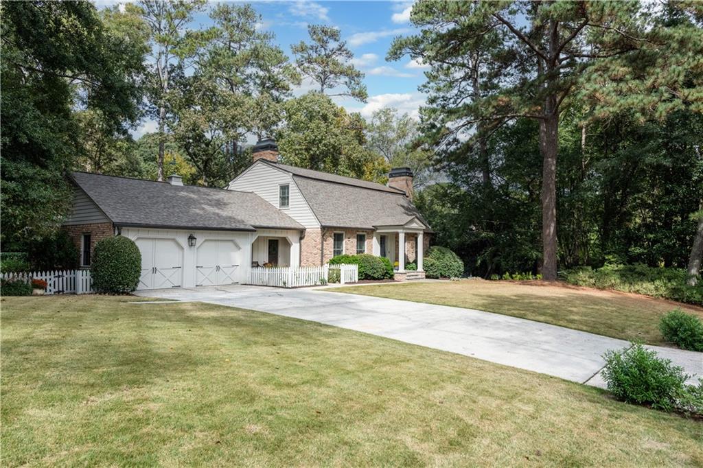 4220 Exeter Close Northwest Atlanta, GA 30327 - Photo 57 of 61 a front view of a house with a garden and trees