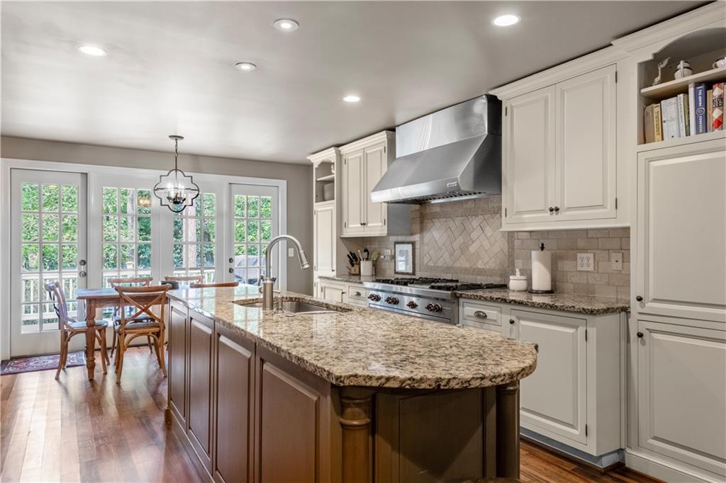 4220 Exeter Close Northwest Atlanta, GA 30327 - Photo 7 of 61 a kitchen with granite countertop a stove a sink a refrigerator and white cabinets with wooden floor