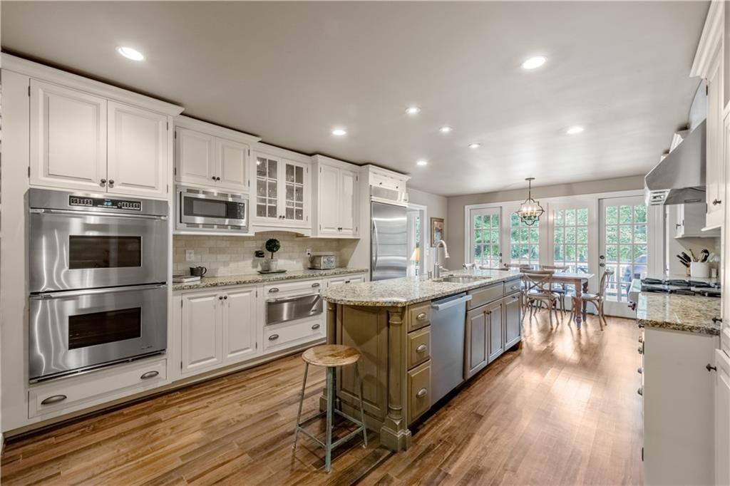 4220 Exeter Close Northwest Atlanta, GA 30327 - Photo 8 of 61 an open kitchen with wooden floor and stainless steel appliances