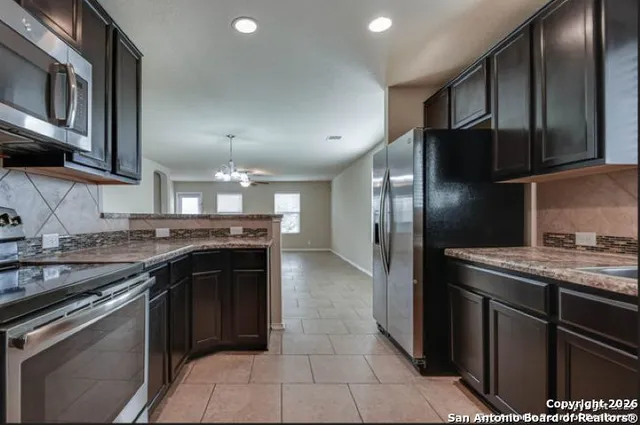 a kitchen with stainless steel appliances granite countertop a stove a sink and a refrigerator