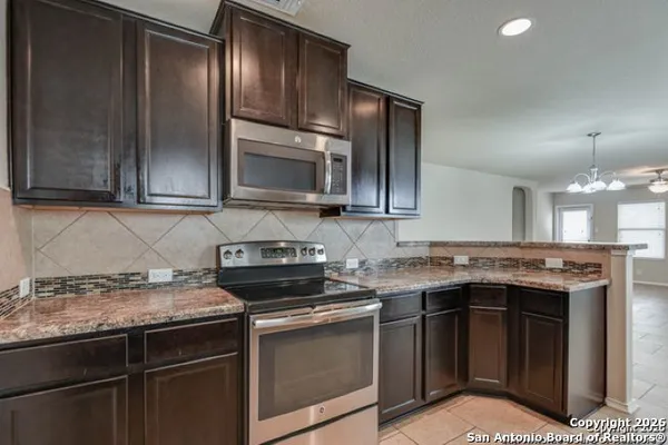 a kitchen with stainless steel appliances granite countertop a stove a sink and a microwave