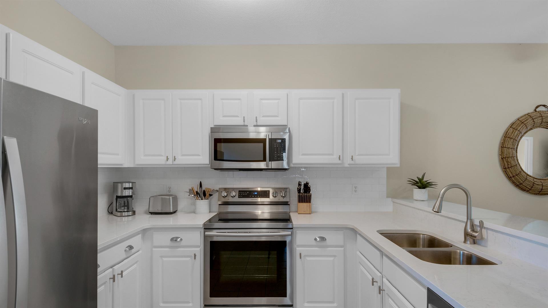 34 Heron's Watch Way, Unit 5101 Santa Rosa Beach, FL 32459 - Photo 14 of 33 a kitchen with stainless steel appliances granite countertop a sink a stove a refrigerator and cabinets