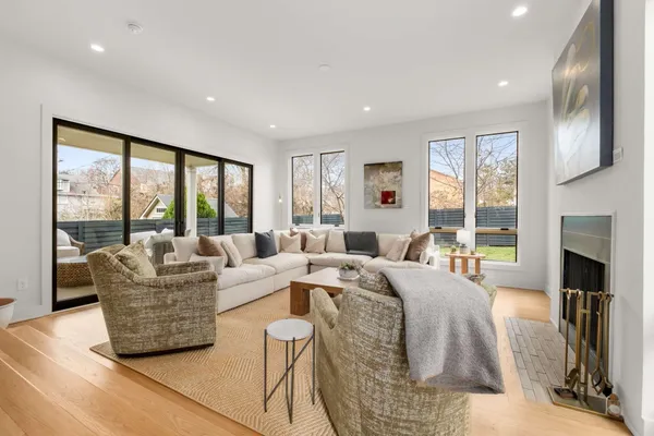 a living room with furniture large windows and a fireplace
