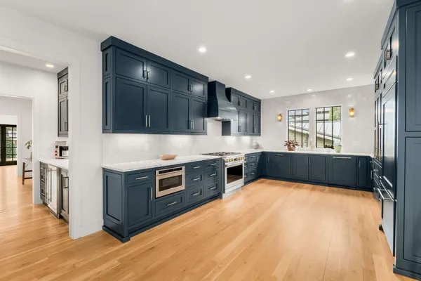 a kitchen with stainless steel appliances granite countertop a refrigerator and wooden cabinets