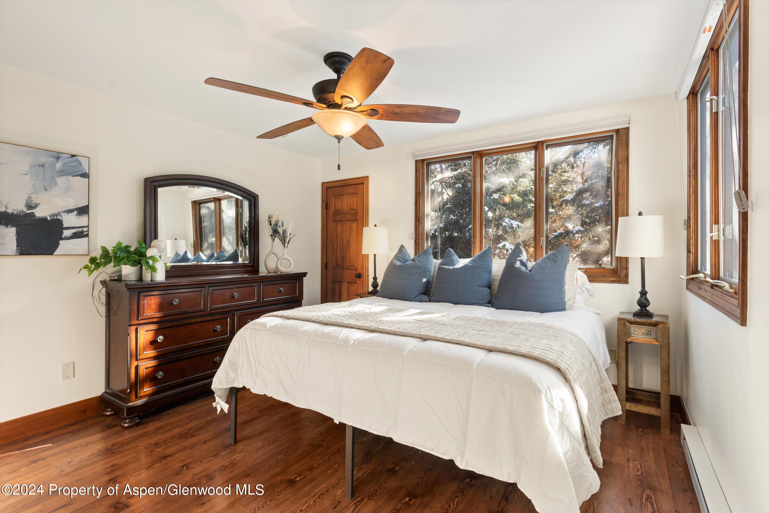 374 Meadow Ranch Road Snowmass Village, CO 81615 - Photo 13 of 22 a bedroom with a bed and a chandelier