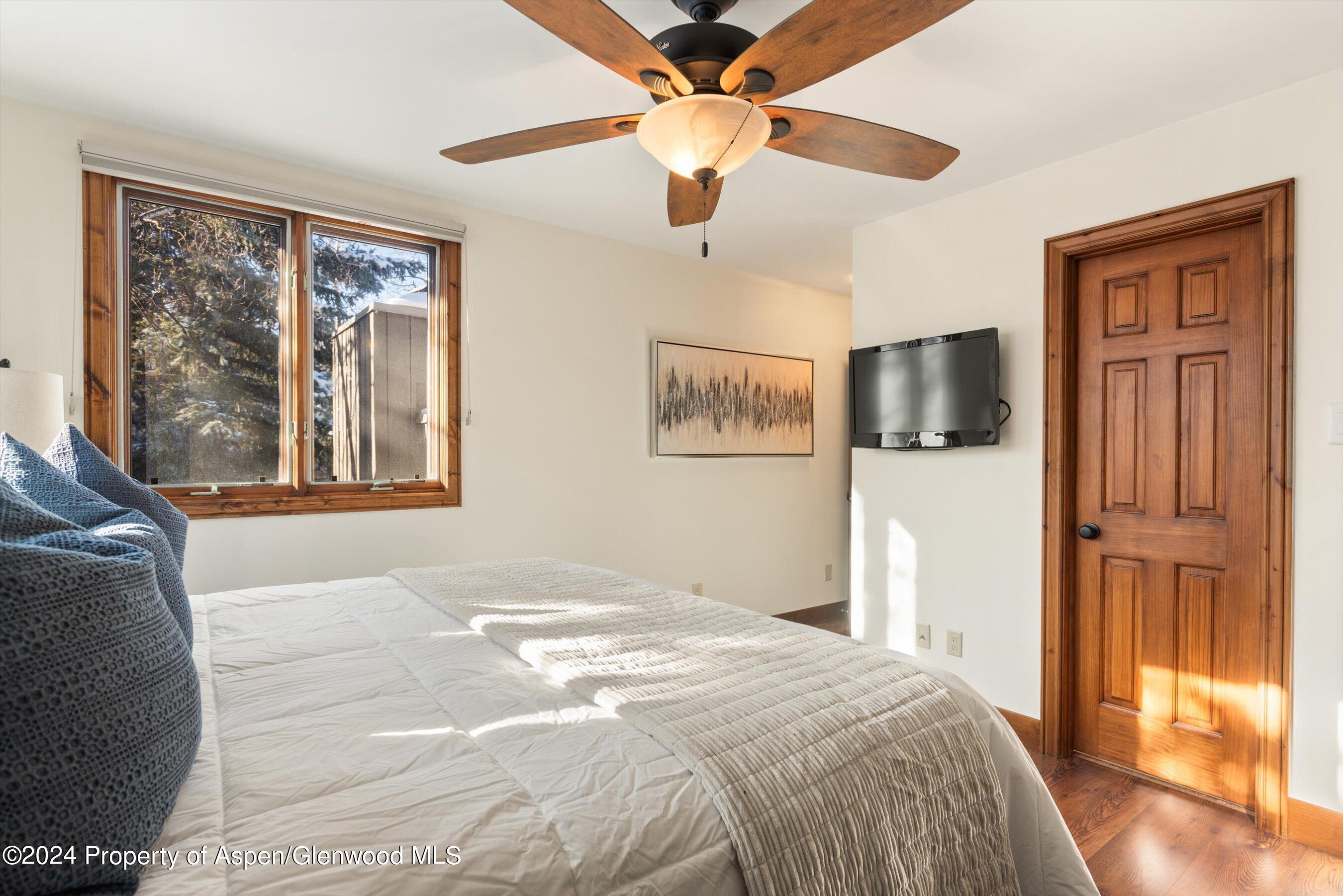 374 Meadow Ranch Road Snowmass Village, CO 81615 - Photo 14 of 22 a bedroom with a bed and a flat screen tv