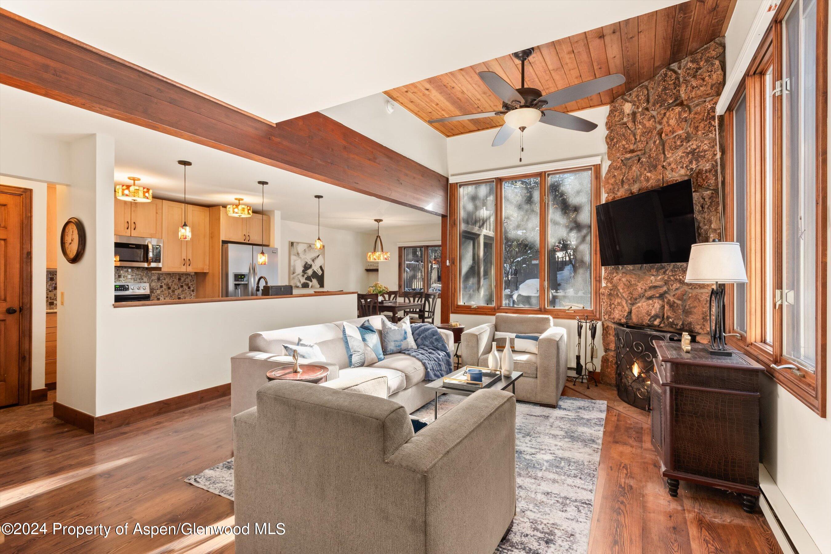 374 Meadow Ranch Road Snowmass Village, CO 81615 - Photo 3 of 22 a living room with furniture a flat screen tv and a floor to ceiling window