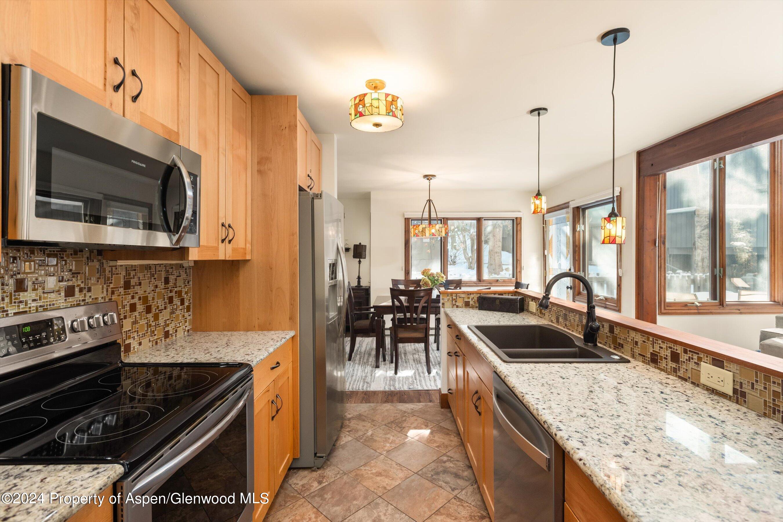 374 Meadow Ranch Road Snowmass Village, CO 81615 - Photo 8 of 22 a kitchen with kitchen island granite countertop a stove a sink and a granite counter tops