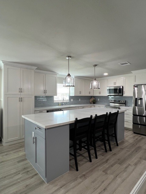 182 County Road 257 Matagorda, TX 77457 - Photo 9 of 24 a kitchen with a dining table chairs wooden floor cabinets and stainless steel appliances