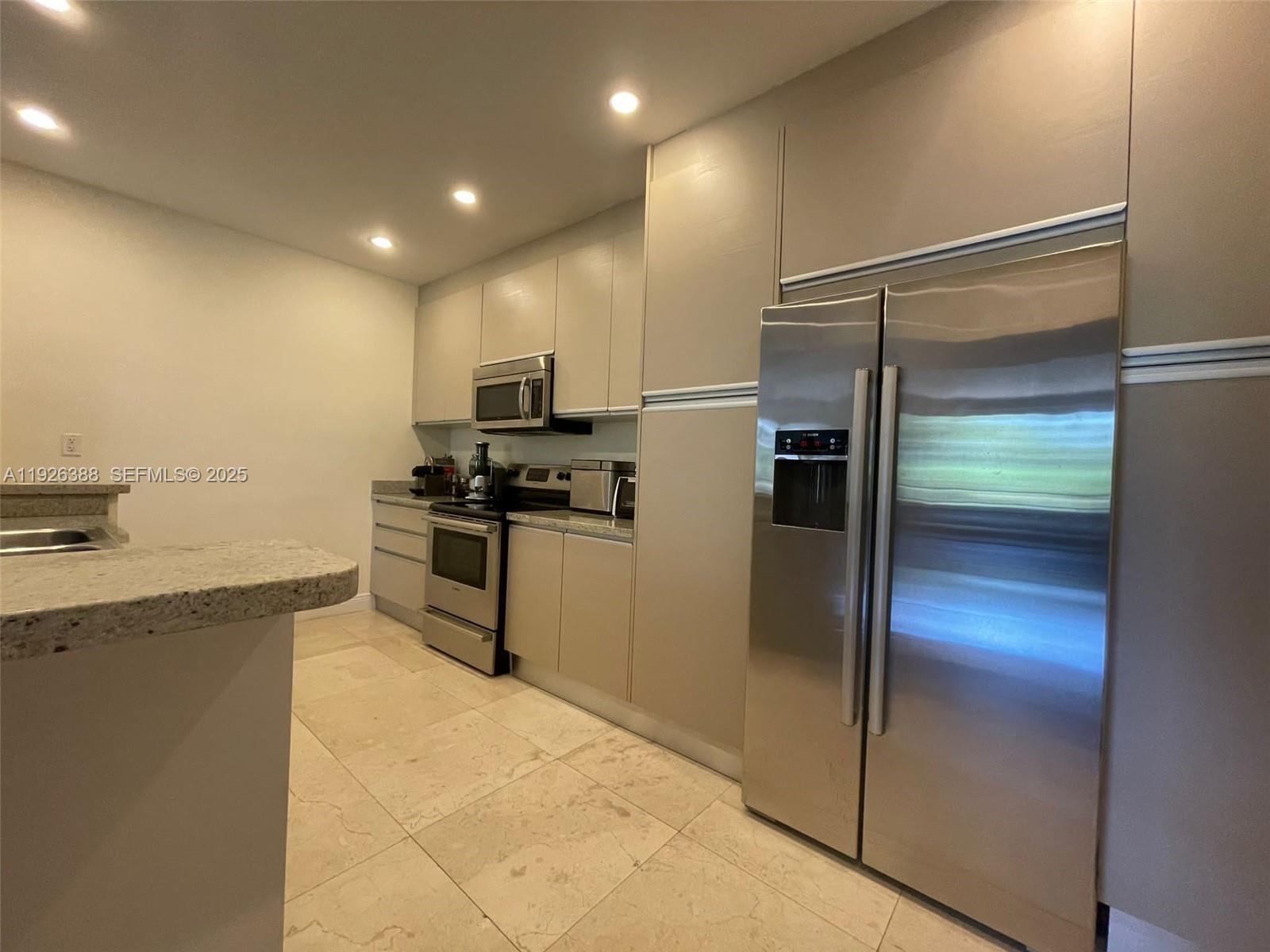 251 Crandon Boulevard, Unit 233 Key Biscayne, FL 33149 - Photo 12 of 27 a kitchen with a refrigerator and a refrigerator