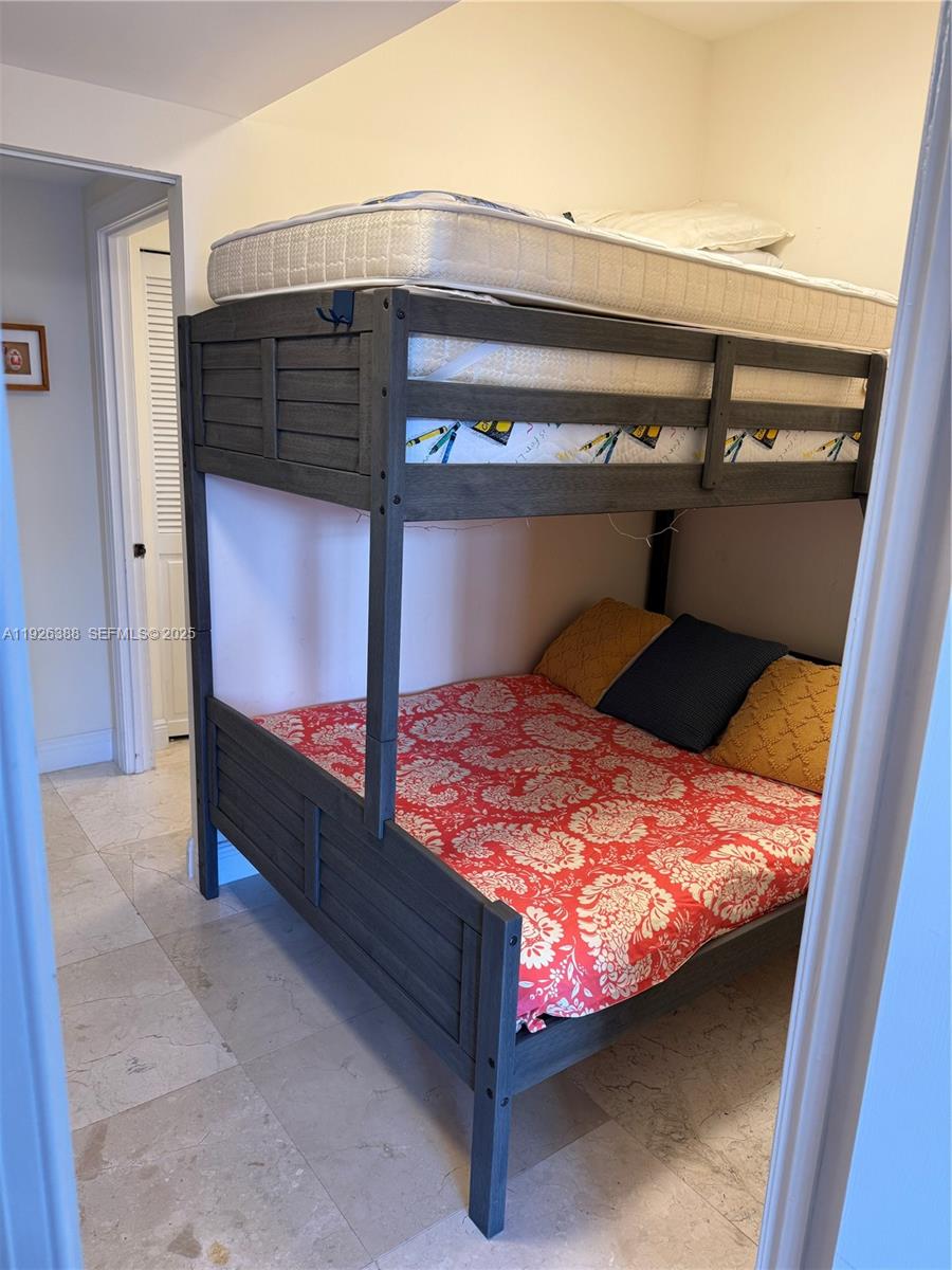 251 Crandon Boulevard, Unit 233 Key Biscayne, FL 33149 - Photo 24 of 27 a bed sitting in a bedroom next to a window