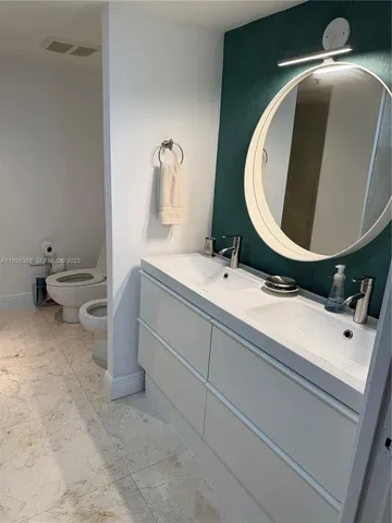 a bathroom with a sink a toilet and a mirror