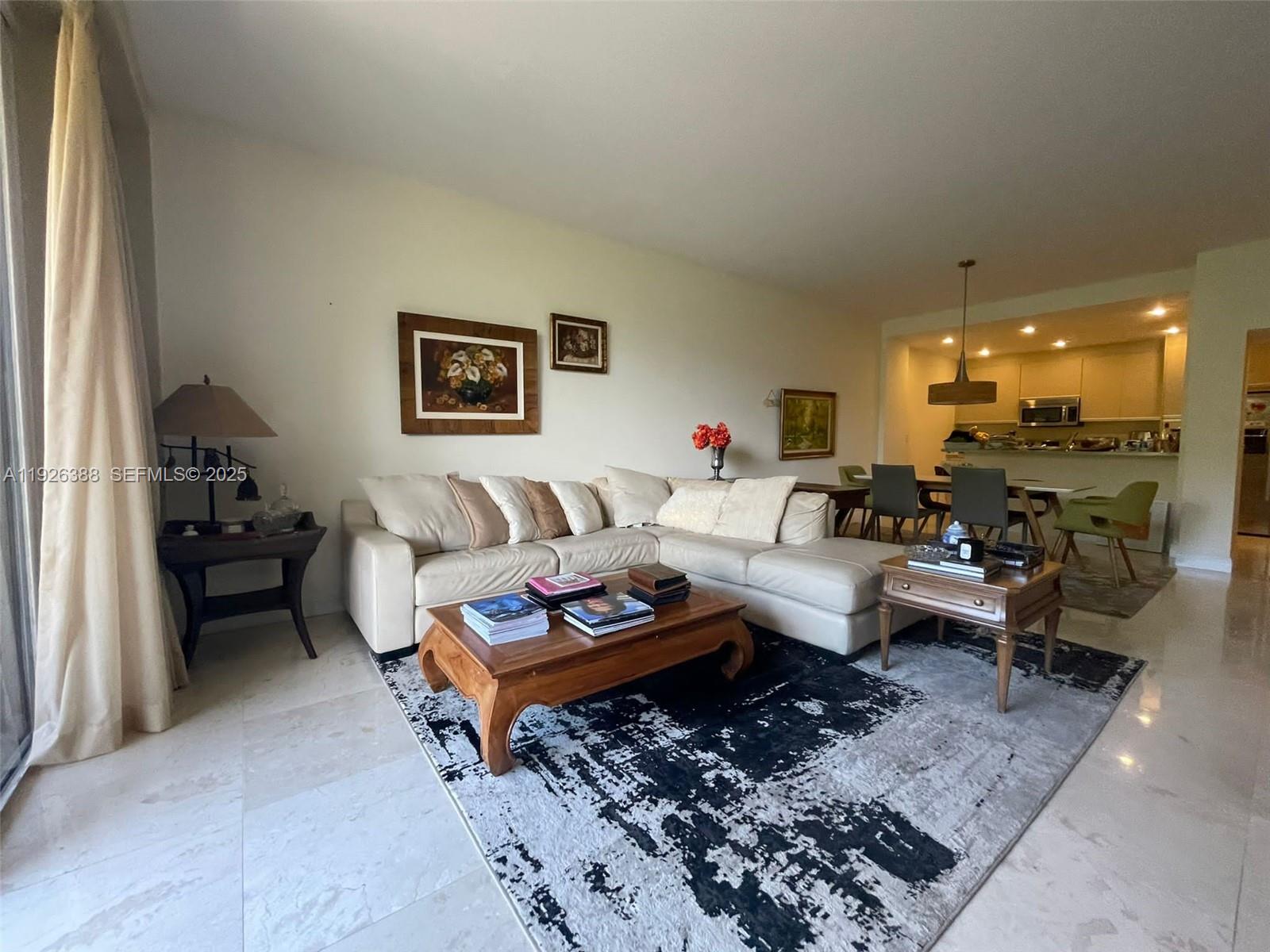 251 Crandon Boulevard, Unit 233 Key Biscayne, FL 33149 - Photo 4 of 27 a living room with furniture and a dining table with wooden floor