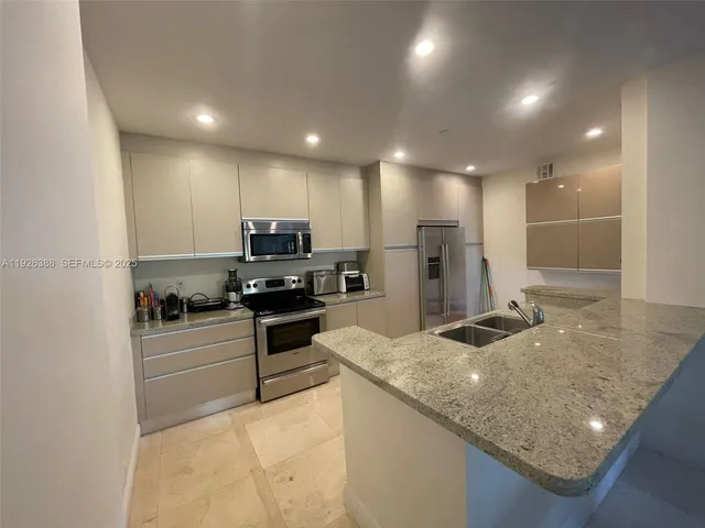 a kitchen with a refrigerator sink and stove