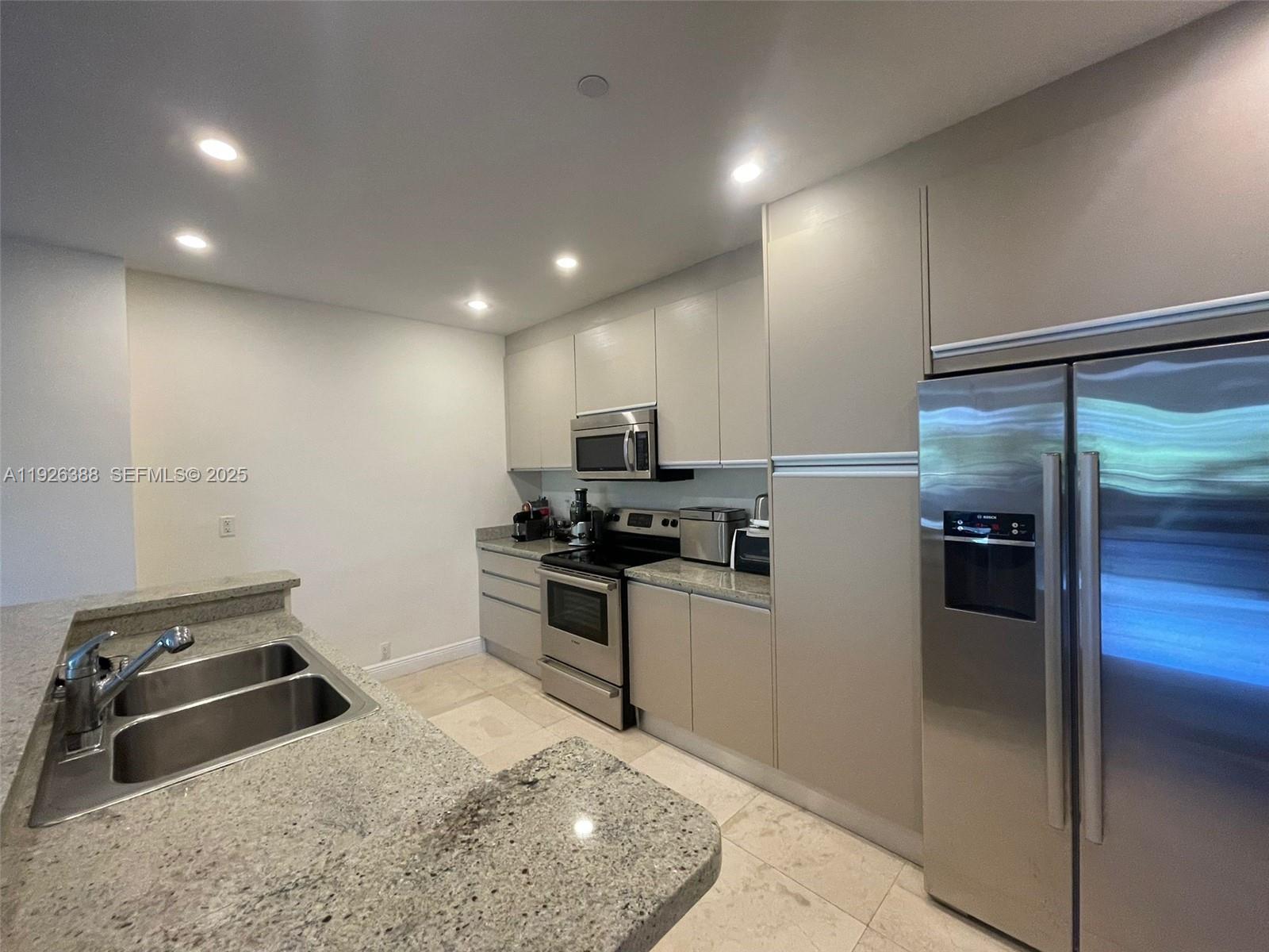 251 Crandon Boulevard, Unit 233 Key Biscayne, FL 33149 - Photo 10 of 27 a kitchen with a refrigerator sink and stove