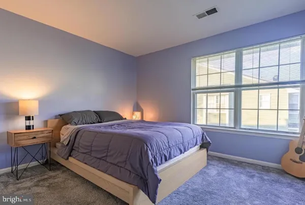 a bedroom with a bed and a lamp