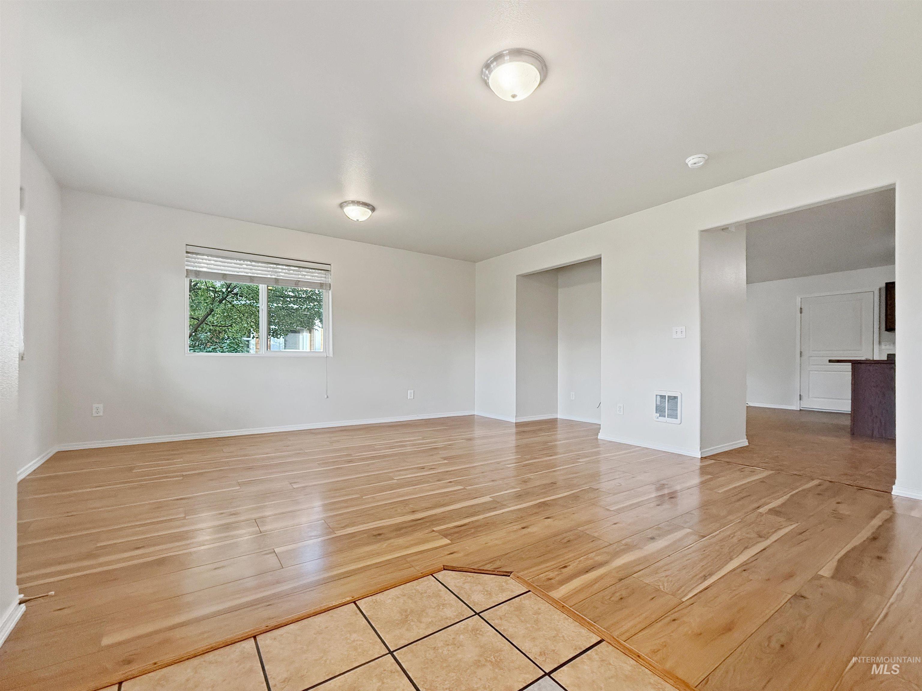 1354 Bristol Road Moscow, ID 83843 - Photo 5 of 19 Spacious room featuring wood-finish flooring, white walls, and a large window with blinds