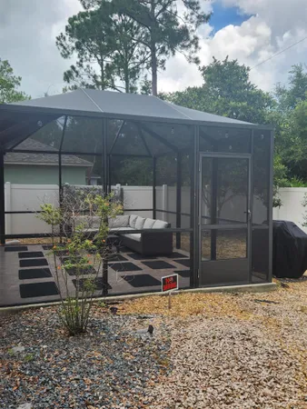 a backyard of a house with barbeque oven table and chairs