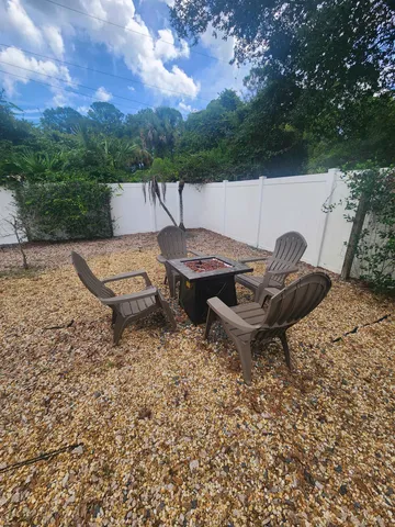 a backyard of a house with barbeque oven table and chairs