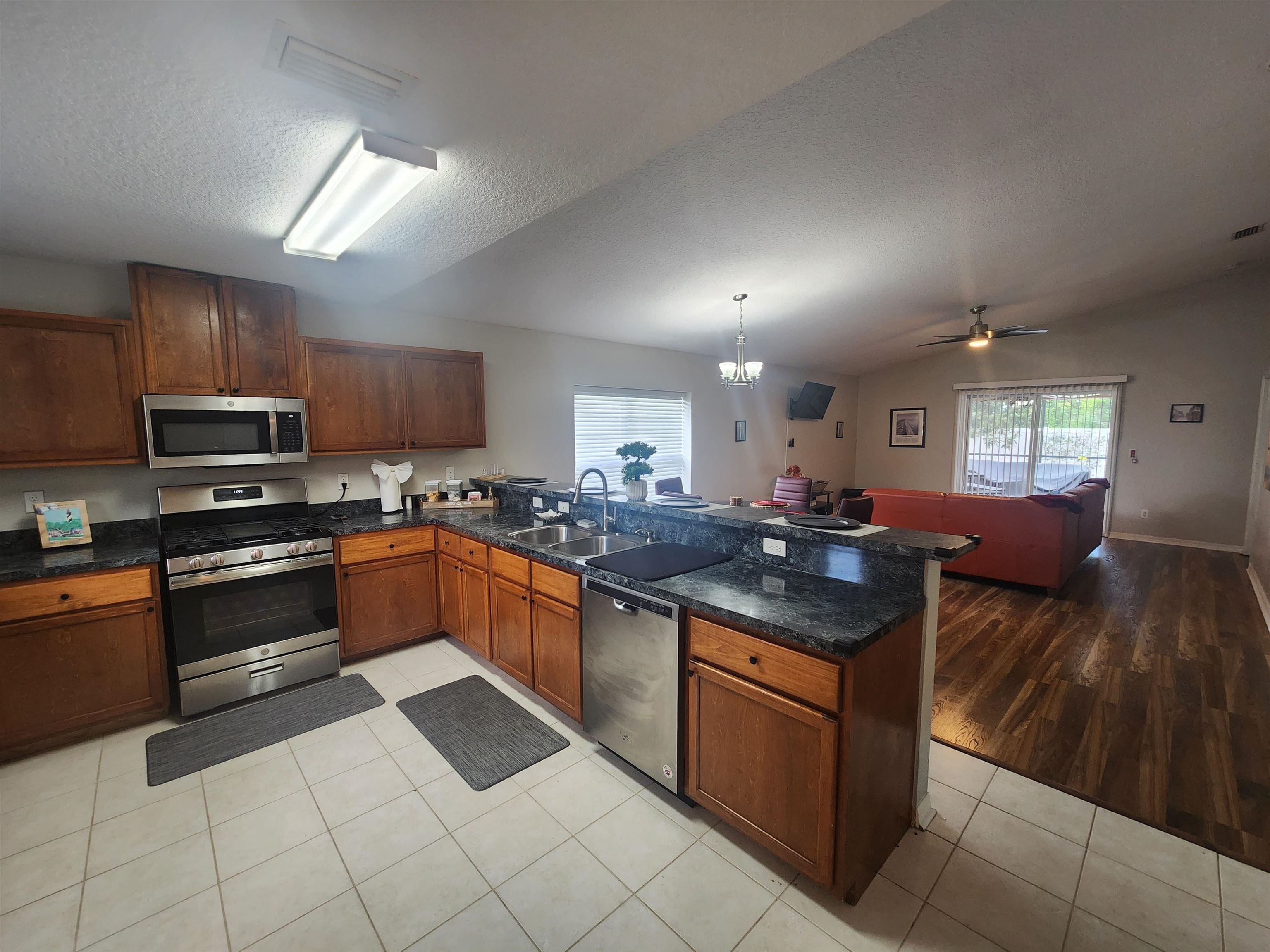 162 Stewart Street St. Augustine, FL 32084 - Photo 23 of 23 a kitchen with stainless steel appliances granite countertop a stove sink and cabinets