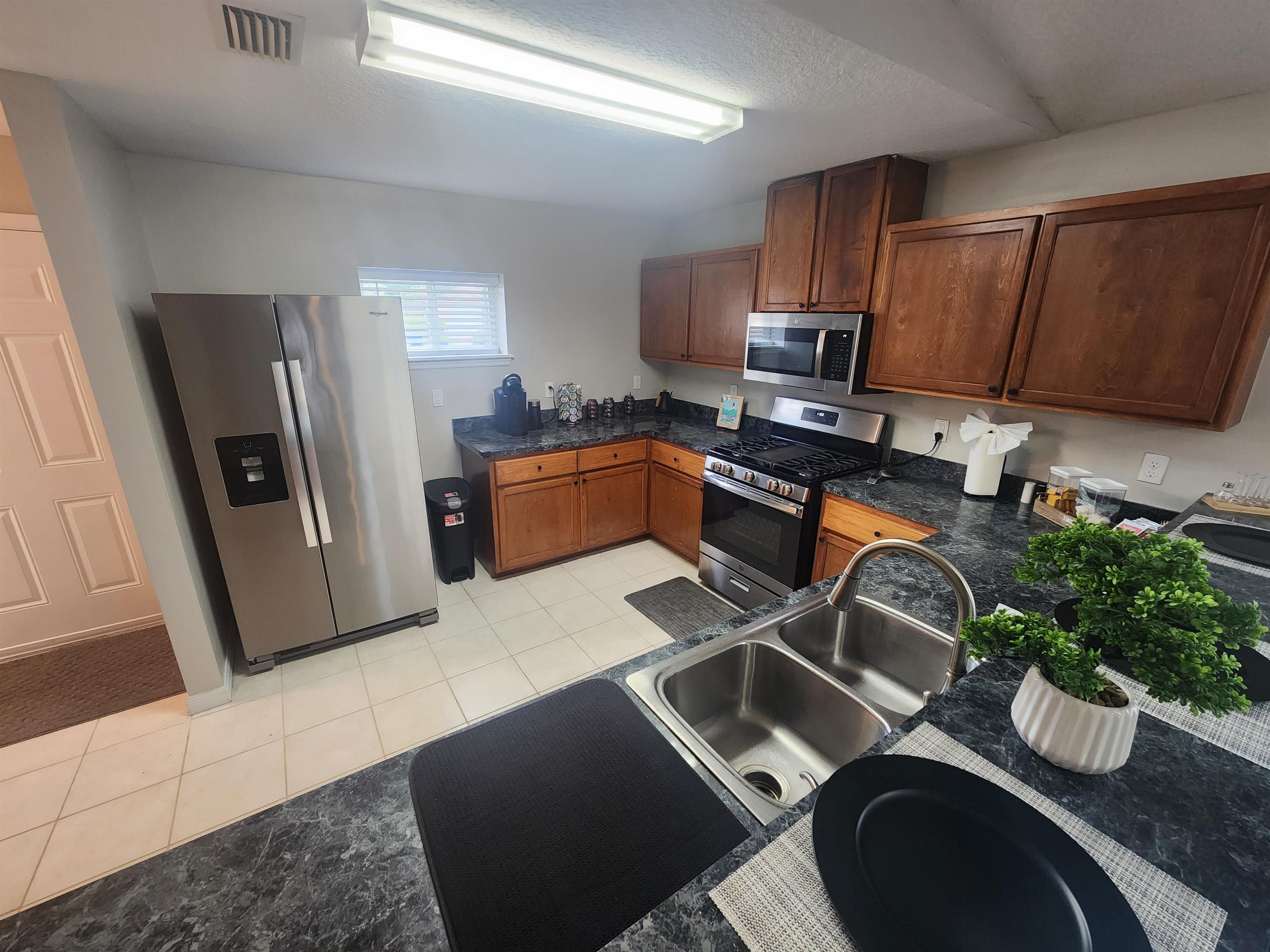 162 Stewart Street St. Augustine, FL 32084 - Photo 4 of 23 a kitchen with stainless steel appliances granite countertop a sink refrigerator stove and microwave