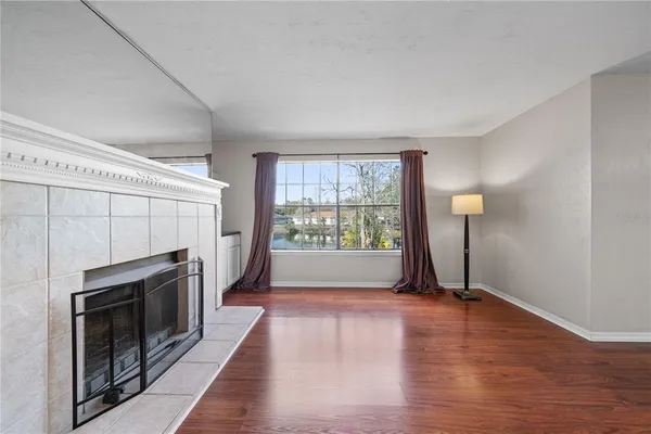 a living room with a fireplace windows and a ceiling fan