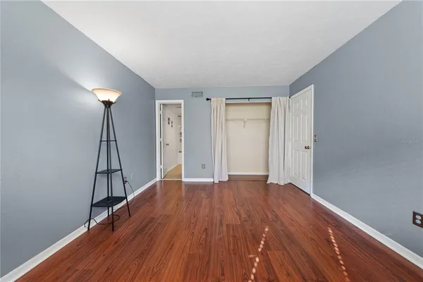 a view of empty room with wooden floor and ceiling fan