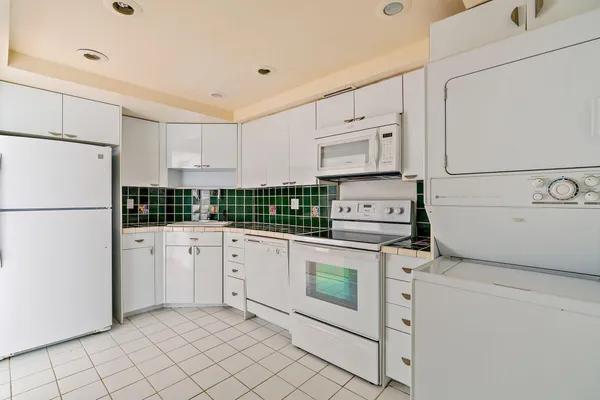 a kitchen with stainless steel appliances granite countertop white refrigerator stove a sink and dishwasher