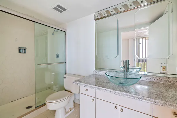 a bathroom with a granite countertop sink toilet and shower