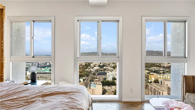 a view of a bedroom with wooden floor and a window