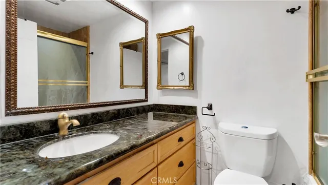 a bathroom with a granite countertop sink and a mirror