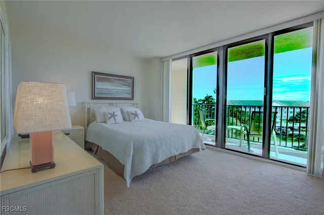 a spacious bedroom with a balcony a bed and a large window