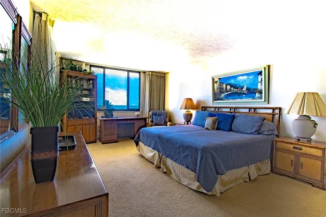 a spacious bedroom with a bed window and table