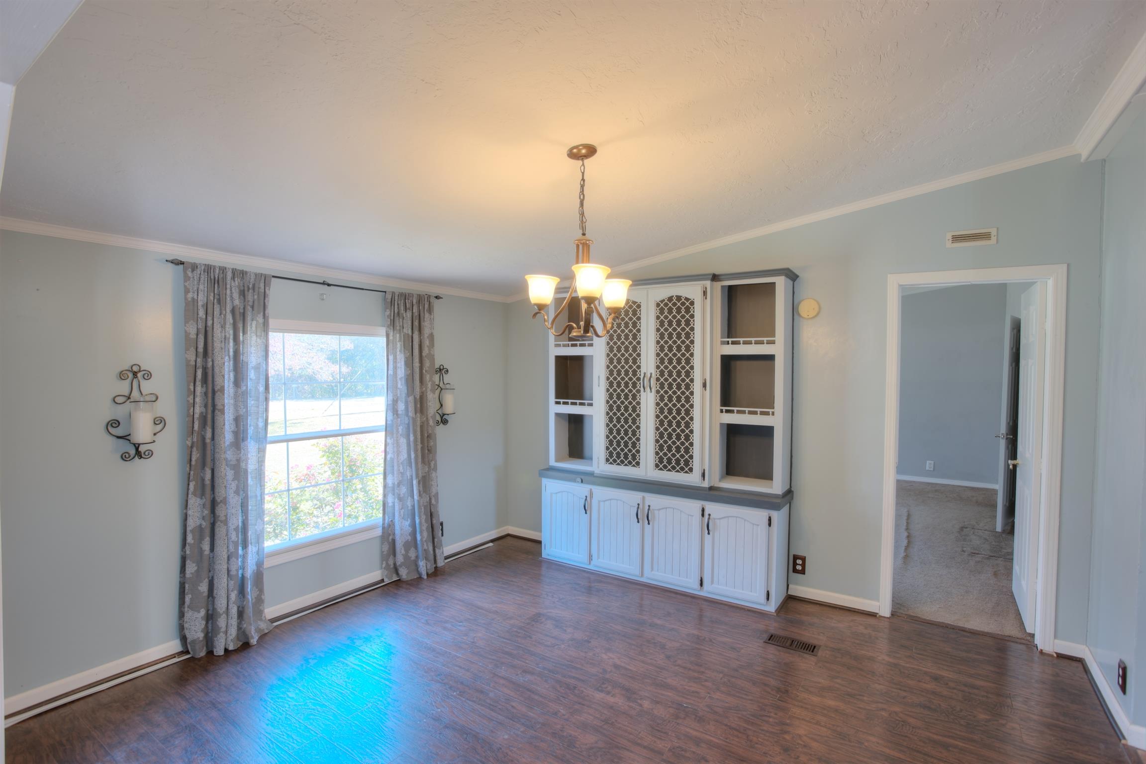 3343 Ridge Road Columbia, TN 38401 - Photo 10 of 27 an empty room with wooden floor chandelier and windows