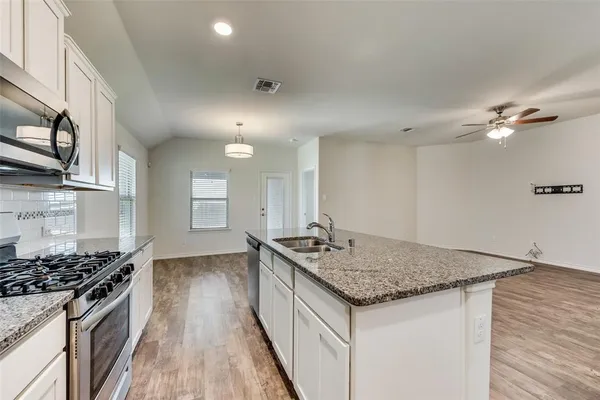 a kitchen with stainless steel appliances granite countertop a sink stove and cabinets