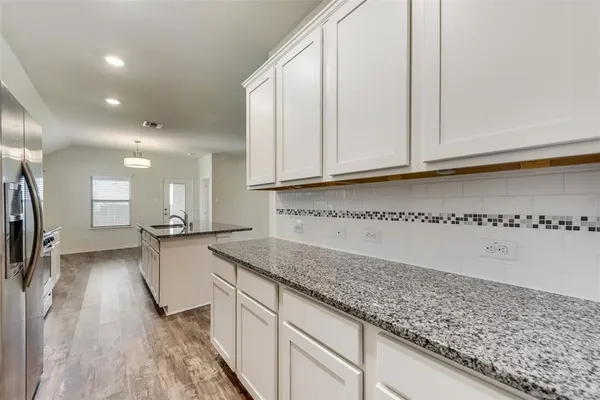 a kitchen with granite countertop a sink and cabinets