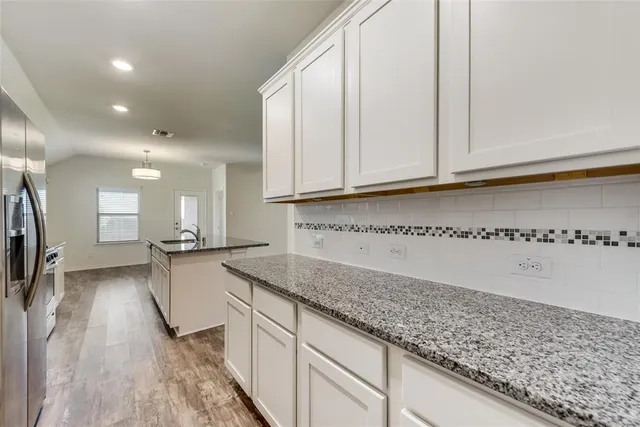 a kitchen with granite countertop a sink and cabinets