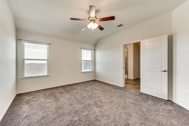 an empty room with closet and ceiling fan