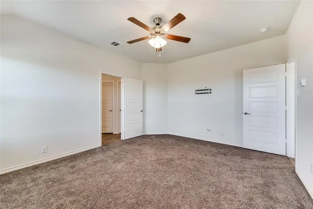 an empty room with closet and ceiling fan