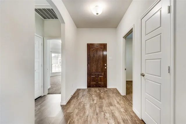 a view of a hallway with wooden floor and closet