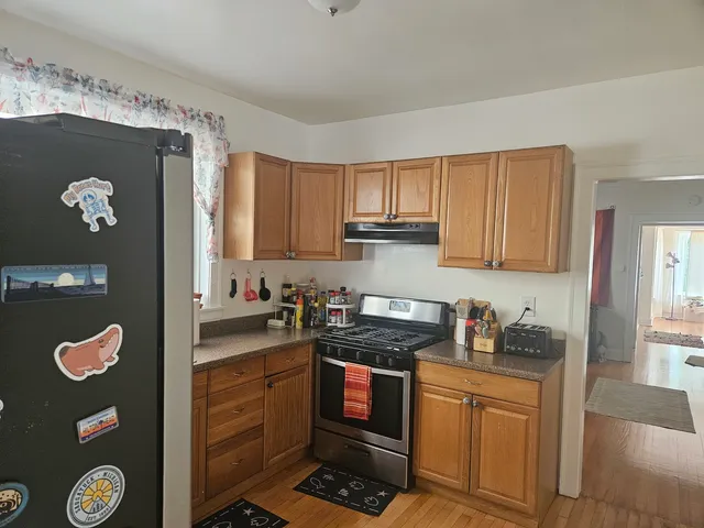 a kitchen with stainless steel appliances granite countertop a refrigerator and a stove top oven