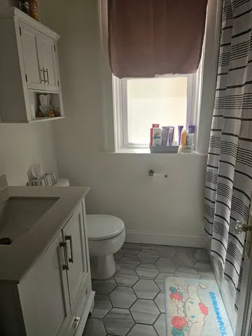 a bathroom with a sink toilet and window
