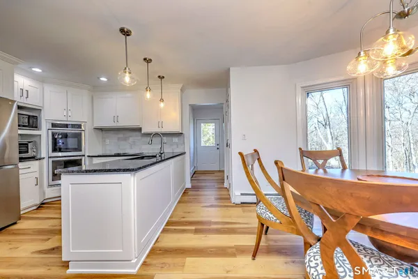 a large kitchen with stainless steel appliances kitchen island granite countertop a large island in the center