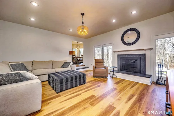 a living room with furniture a fireplace and a ceiling fan