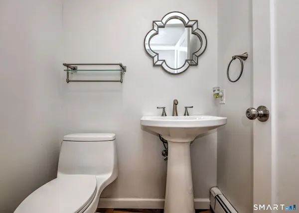 a bathroom with a toilet a sink and mirror