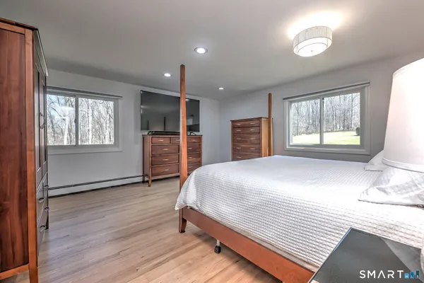 a bedroom with a bed dresser and a window