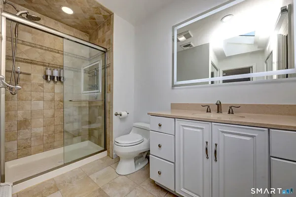a bathroom with a sink a toilet and shower